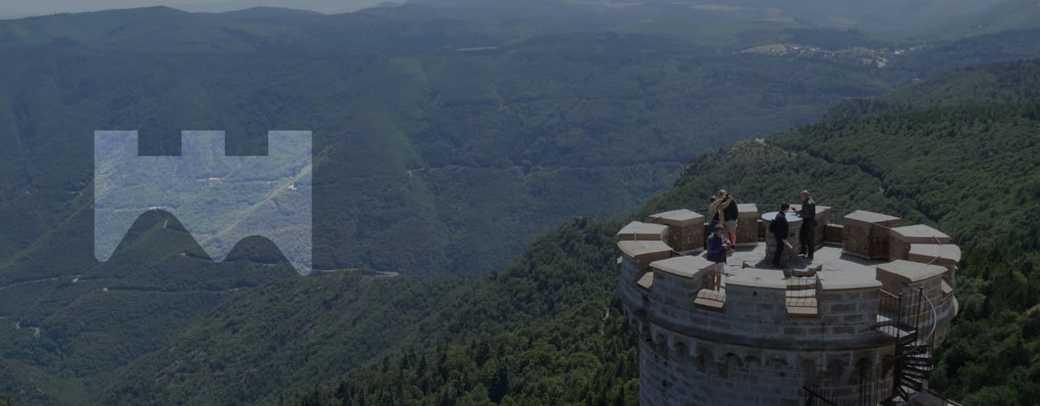 Personnes sur la tour de l'observatoire, ils ont une vue panoramique sur les montagnes arborées